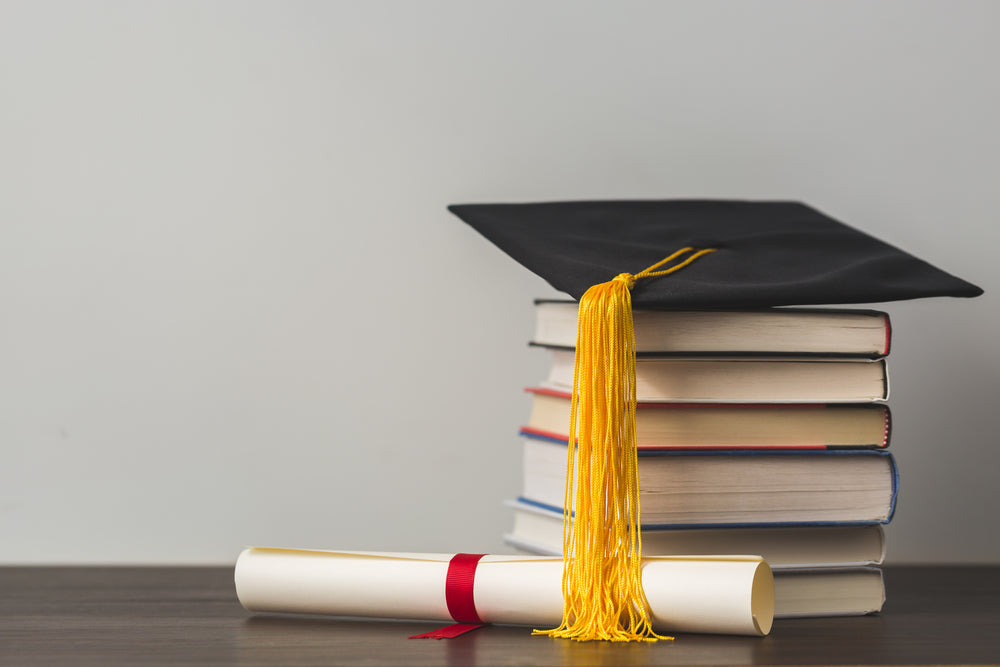 grad-cap-diploma-and-stacked-books